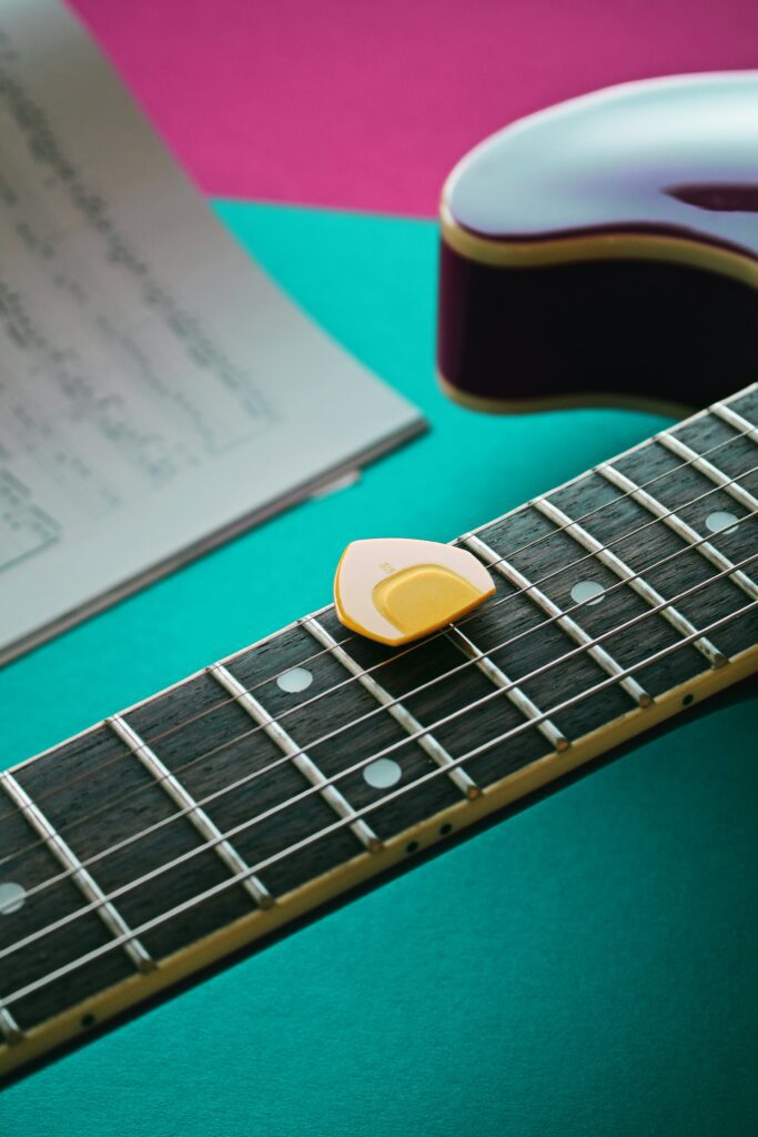 uma guitarra com uma palheta em cima das cordas.